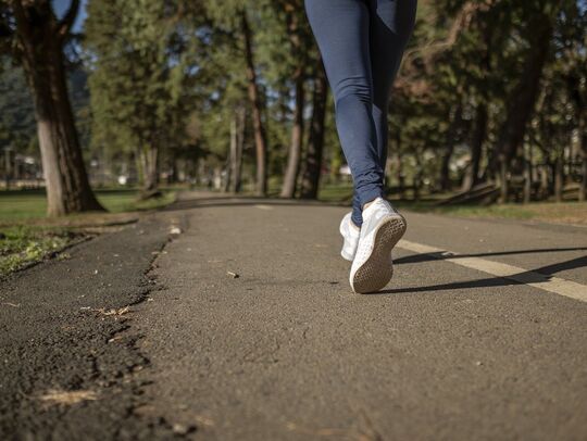 route sur laquelle on voit les pieds d'un coureur
