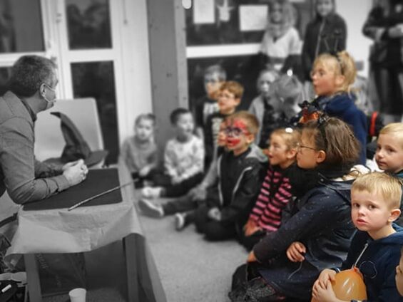 Enfants assis devant un spectacle de magie