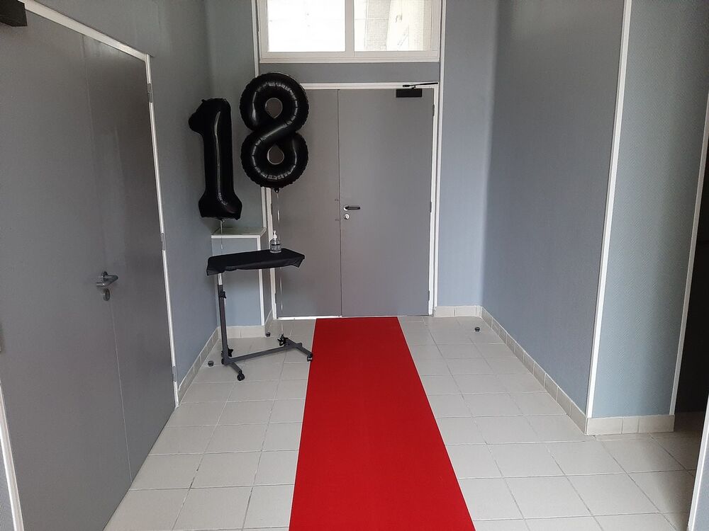entrée de salle avec tapis rouge et ballons 