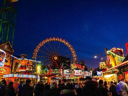 grande roue dans le fond d'une fête foraine le soir